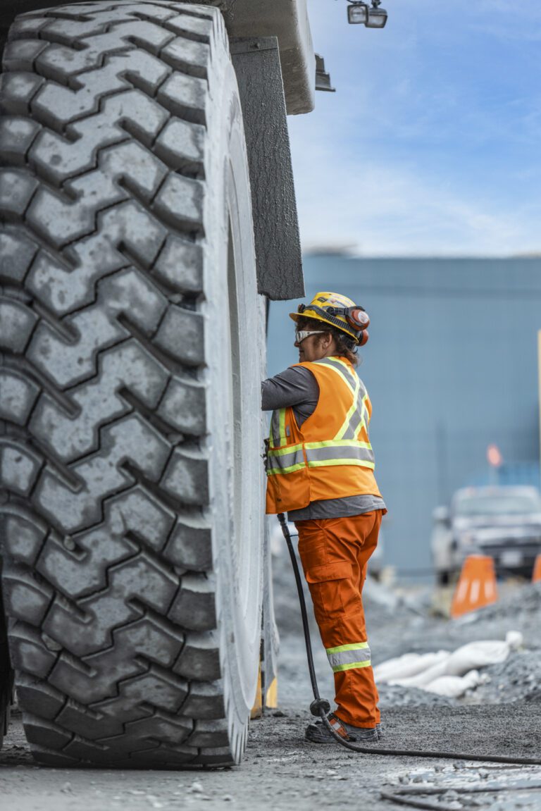 A worker at lac des iles mine fixing a large truck