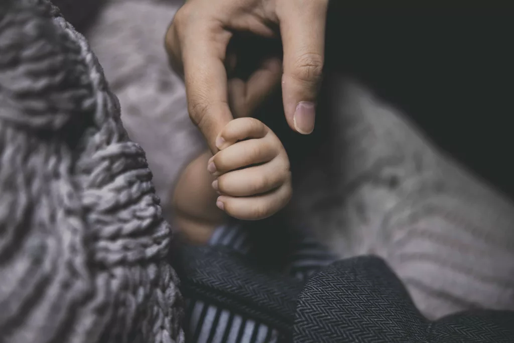 Dads finger in babies hand
