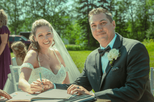 Amanda and Lance signing their marriage certificate during the wedding ceremony.