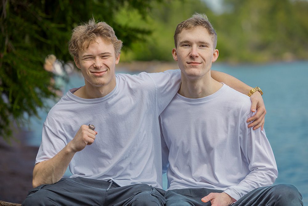 Sarah’s two sons lay together on a blanket at the beach, sharing a carefree moment with Lake Superior in the background—captured through Photography Gift Cards in Thunder Bay.