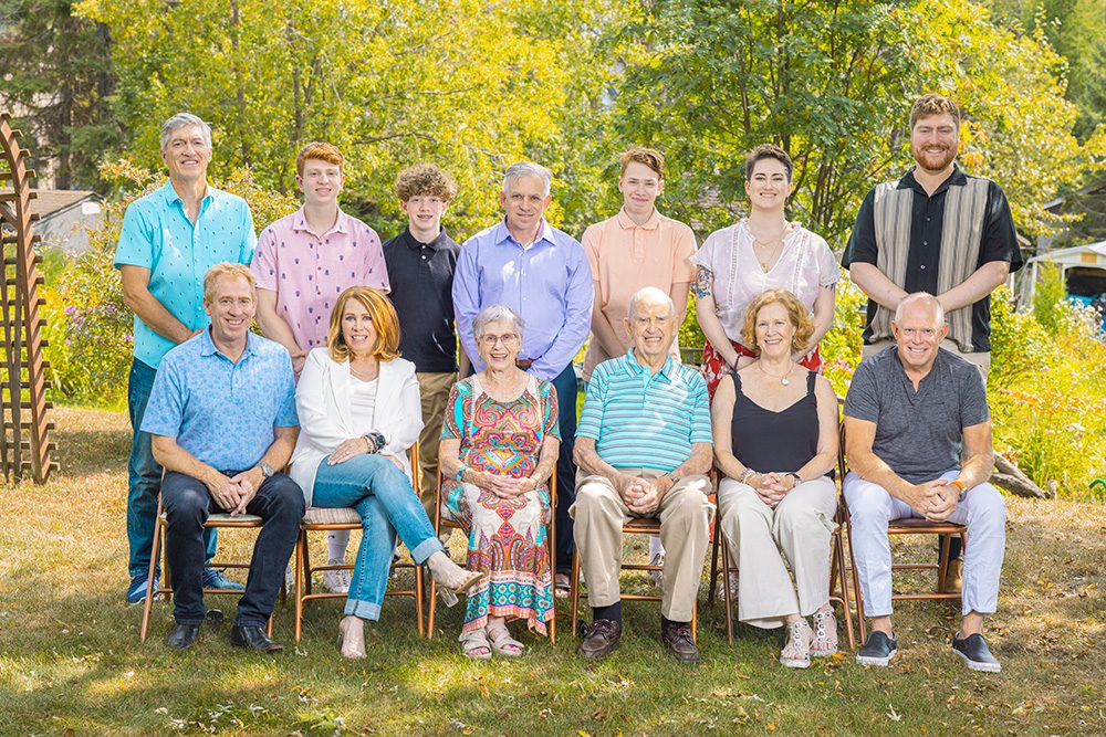 Three generations of Norma’s family smiling at the camera during a summer portrait session in Thunder Bay.