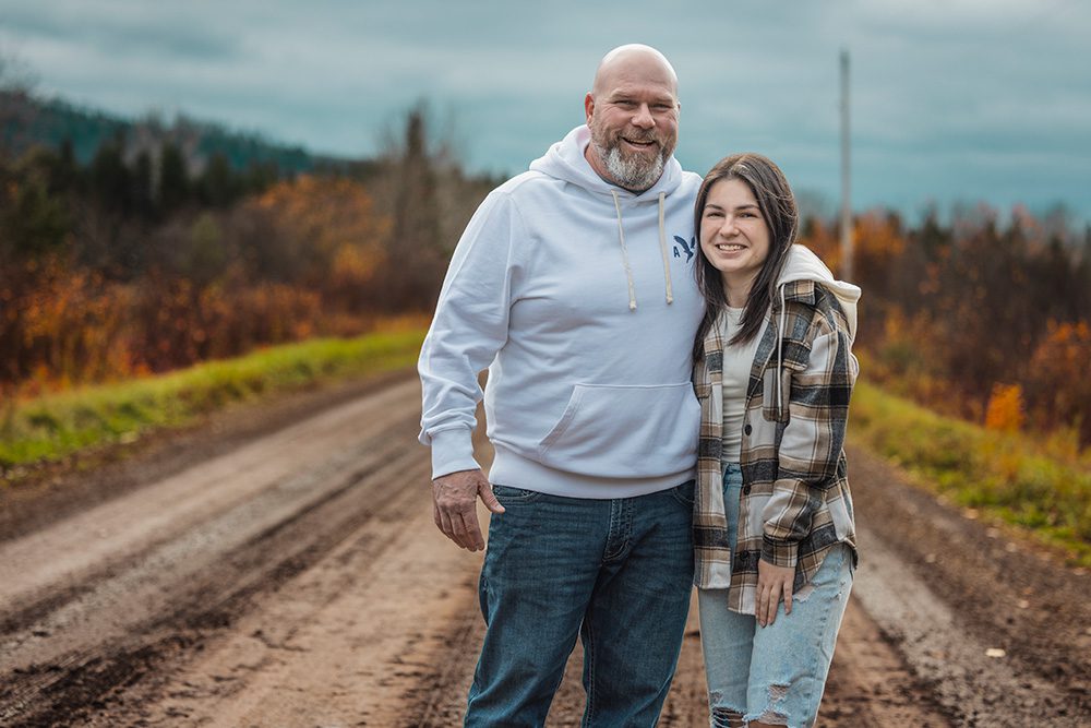 Father and daughter smiling together on a dirt road during Professional family photo session