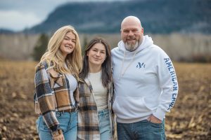 The whole family standing together with a mountain backdrop during family photo session
