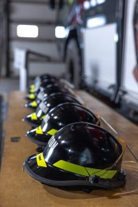 Corporate milestone photography showing firefighter helmets at airport safety graduation ceremony