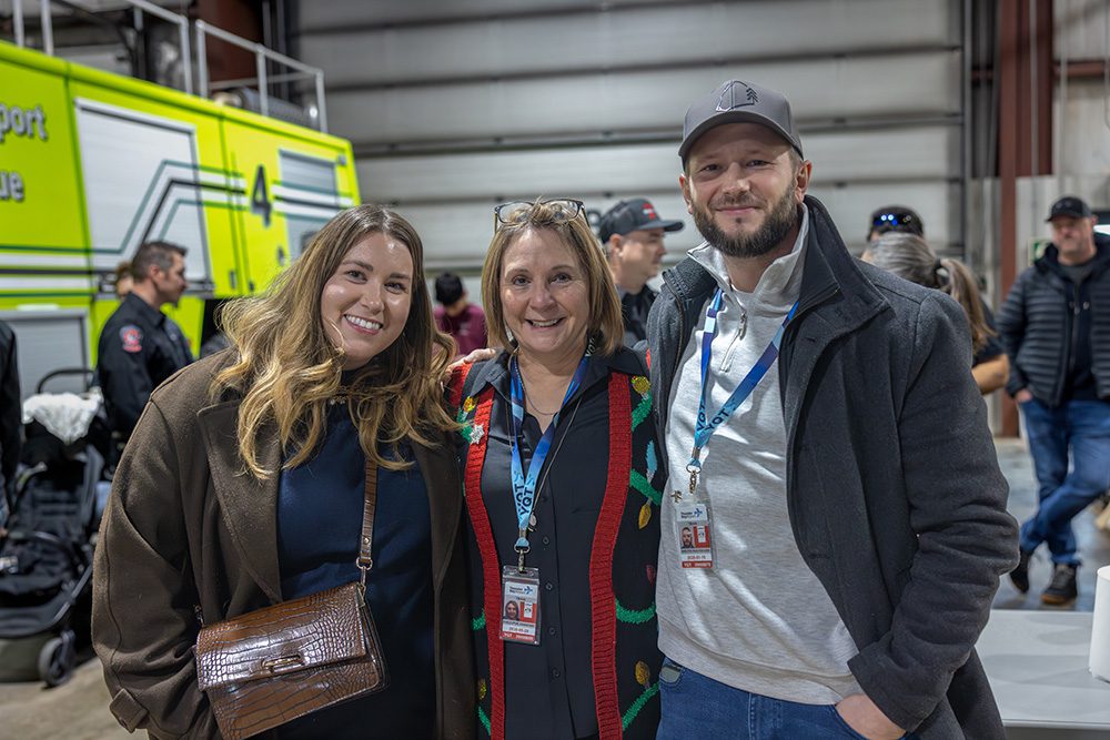Corporate milestone photography showing guests and family at airport safety graduation event
