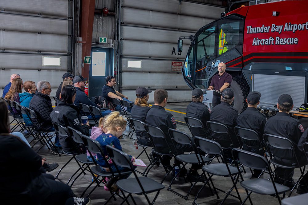Corporate milestone photography of training presentation at airport safety graduation ceremony