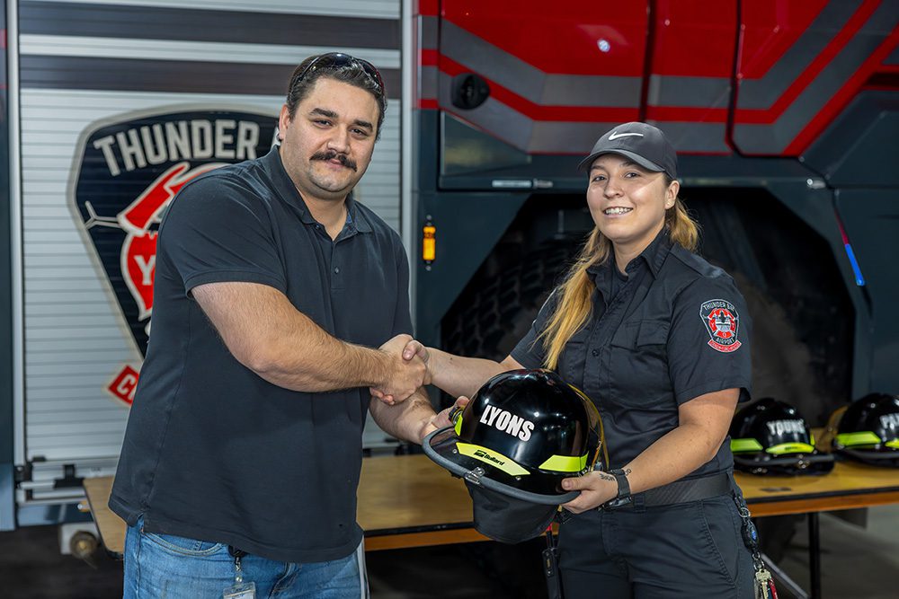 Corporate milestone photography of graduation certificate handshake at airport safety ceremony
