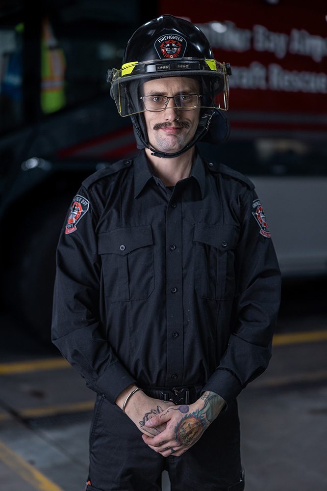 Corporate milestone photography formal headshot of airport firefighter with safety helmet