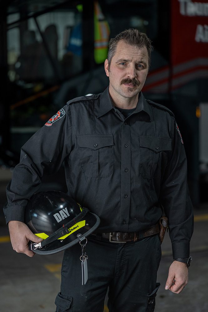 Corporate milestone photography of airport firefighter holding safety helmet professionally