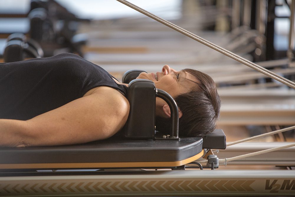 Close-up of woman in focused concentration during Pilates reformer exercise