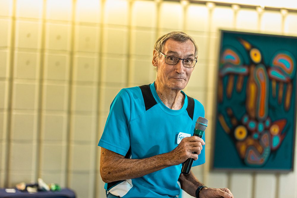 Senior speaker presenting at microphone during Applause business workshop