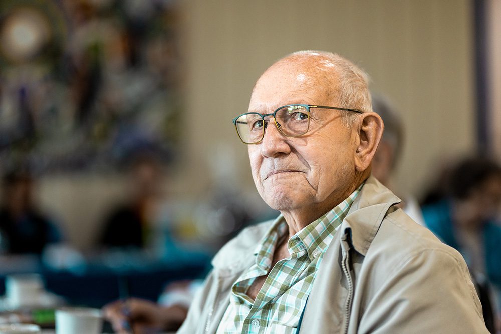Elderly male attendee listening attentively at business seminar