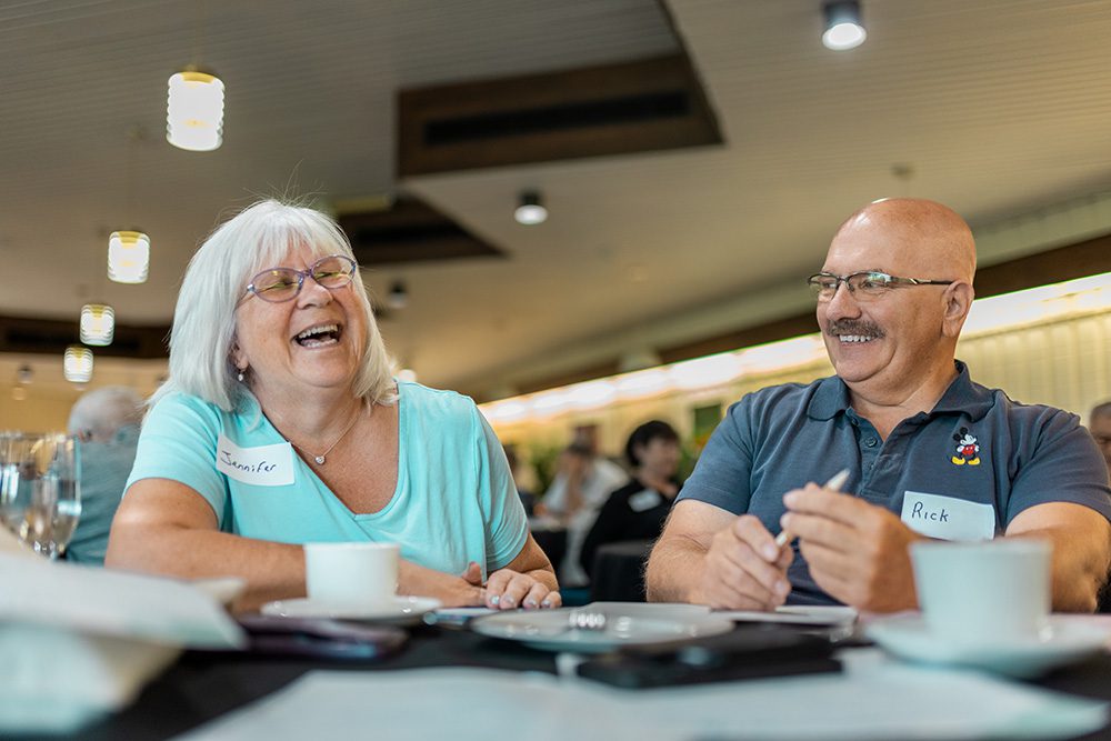 Senior couple laughing together during workshop session at round table