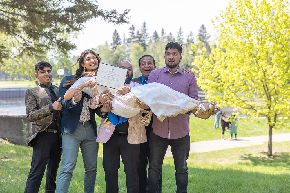 University graduation photography fun group photo with graduate being carried by family members