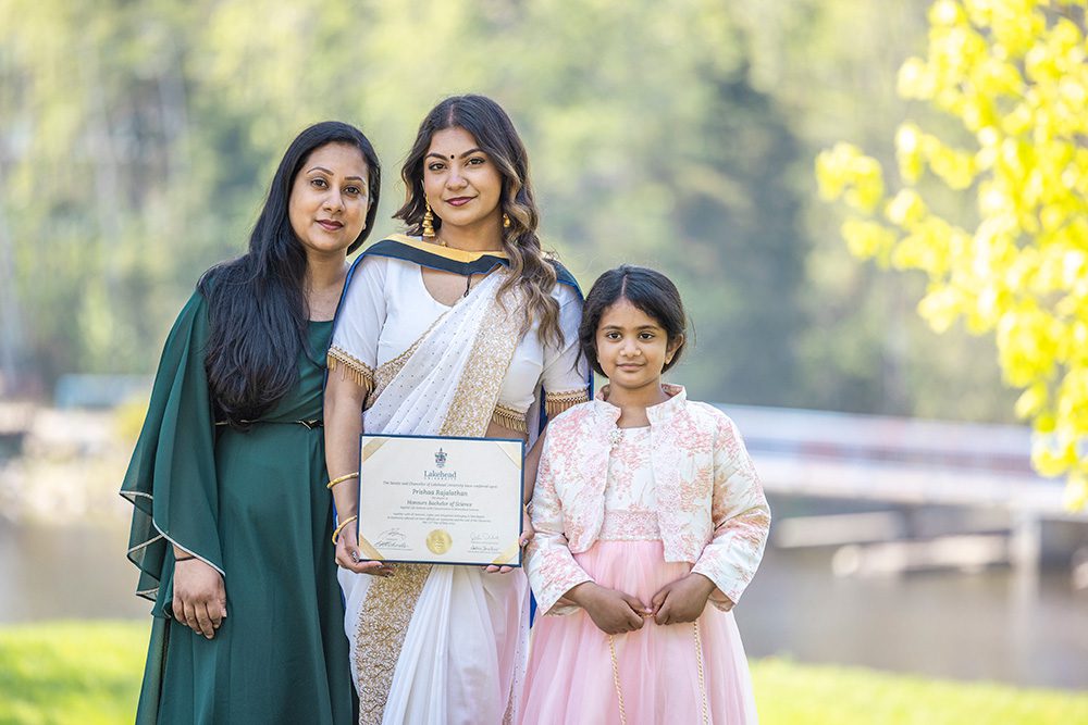 University graduation photography three generation family portrait with graduate holding diploma