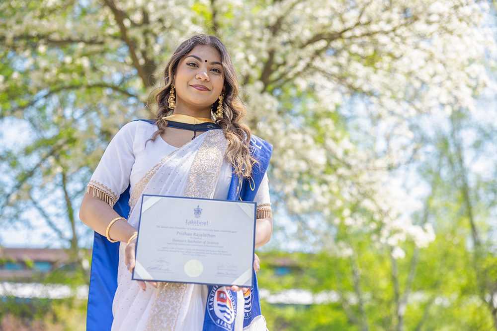 University graduation photography natural outdoor portrait of graduate with diploma and cultural attire
