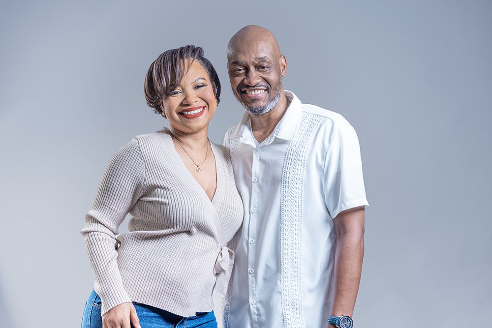 Couple standing together and smiling during an elegant studio anniversary photoshoot