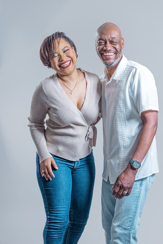 Couple laughing together during a candid anniversary photoshoot in a studio