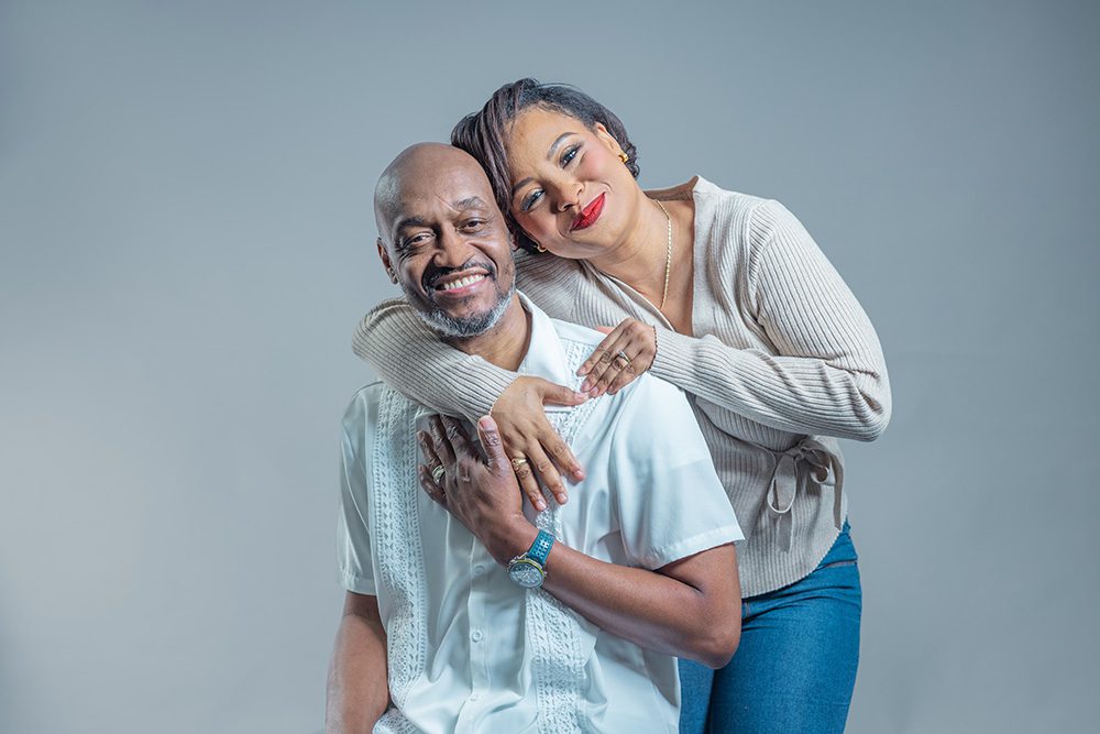 Couple seated together in an intimate pose during a studio anniversary photoshoot
