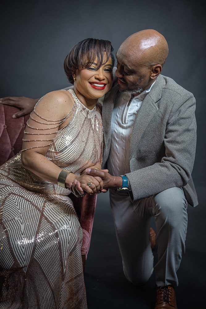 Couple holding hands during an intimate anniversary photoshoot in studio