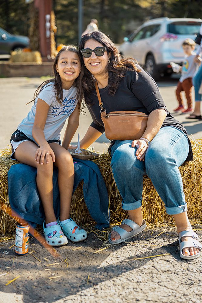 Event advertising photos showing family enjoying outdoor fall craft fair on hay bales