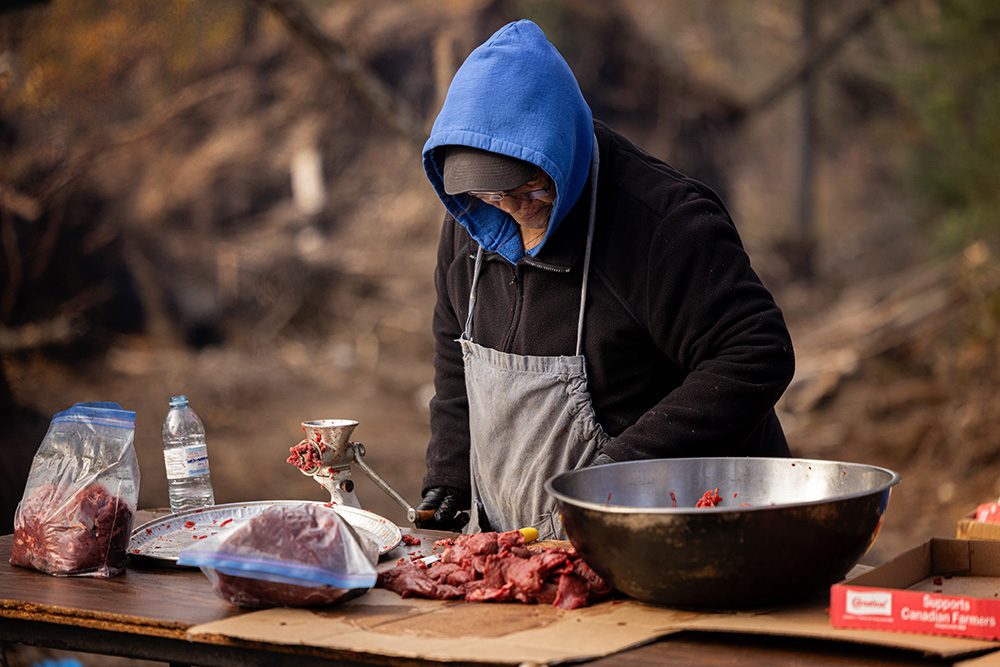 Preparing moose meat using traditional tools during the Moose Festival