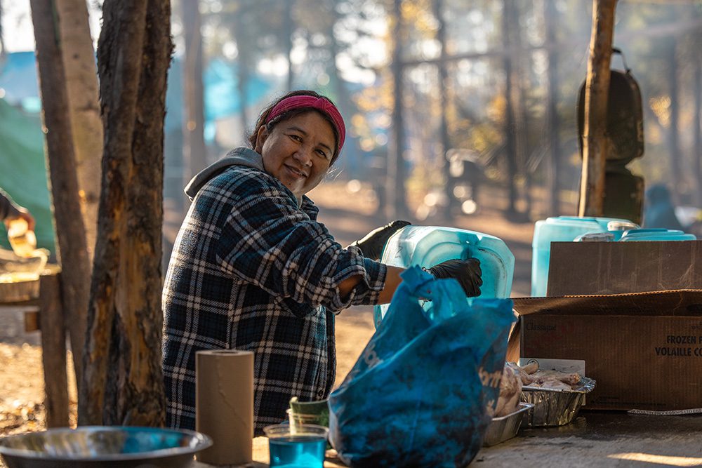 Woman preparing food at an outdoor table during the Moose Festival