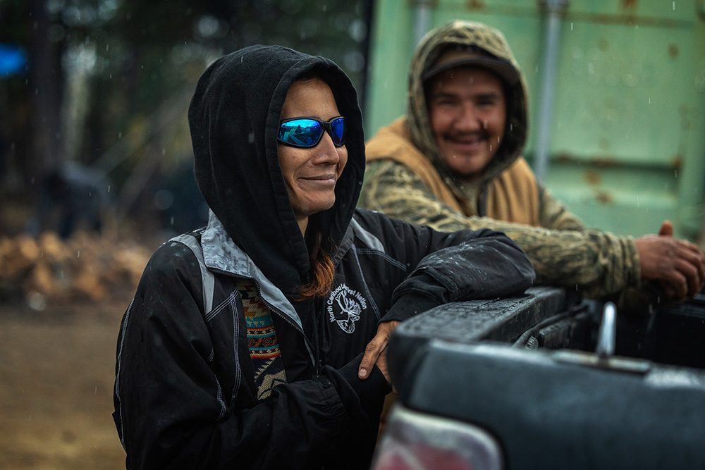 Two community members standing by a truck during rainy weather at the Moose Festival