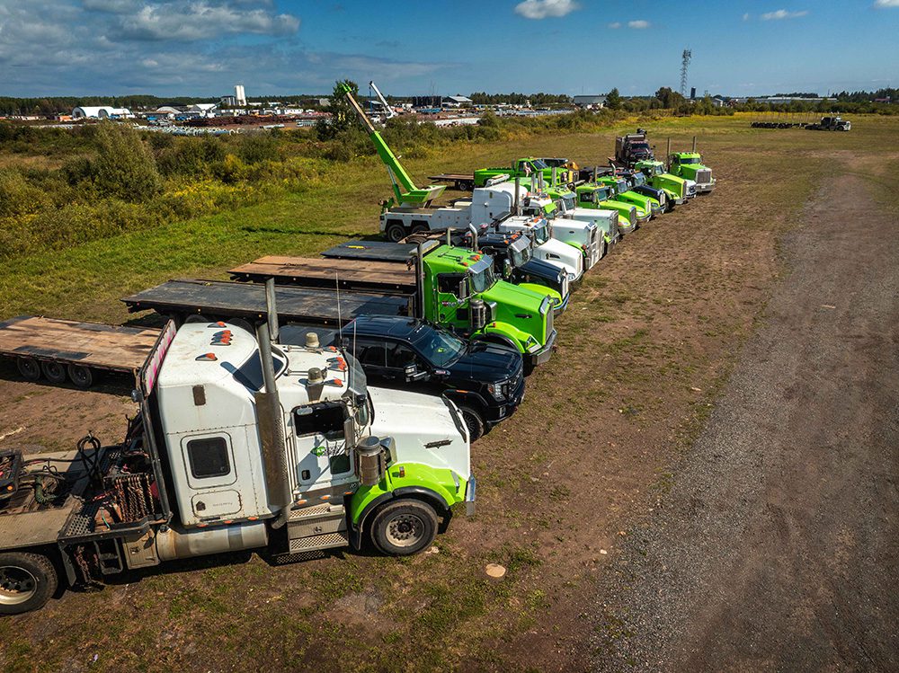 Professional trucking company photography aerial view of Hartley towing fleet with green trucks at company yard