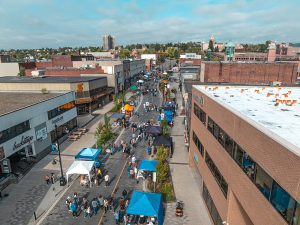 Aerial view of Harvest Fest in downtown Thunder Bay with vendor tents and crowds along the street.
