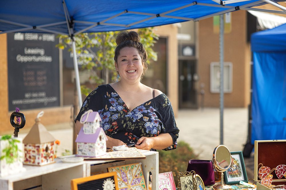 Local vendor smiling at a booth during Harvest Fest in Thunder Bay.