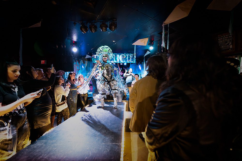 Elaborate silver metallic costume with peacock-like structure on runway
