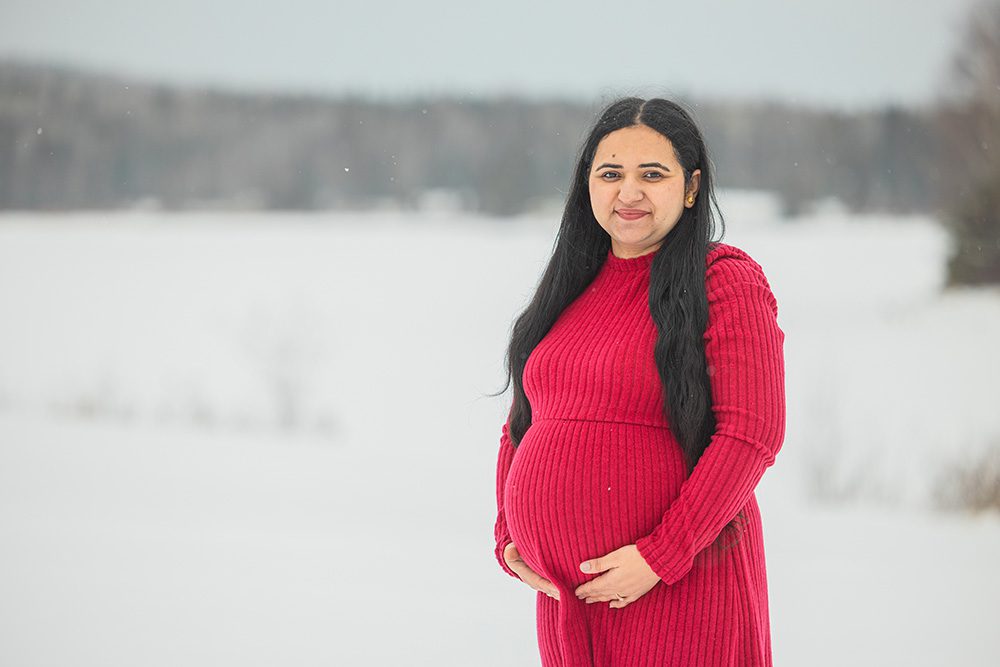 Expecting mother portrait with scenic winter landscape during maternity photoshoot