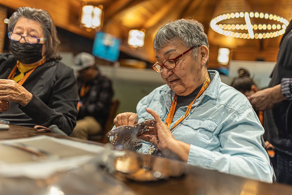Indigenous elder teaching hands-on cultural practice to conference participants