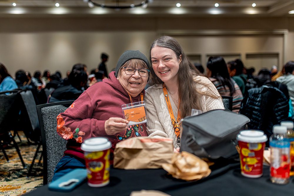 Elder and young woman sharing warm moment together at conference table