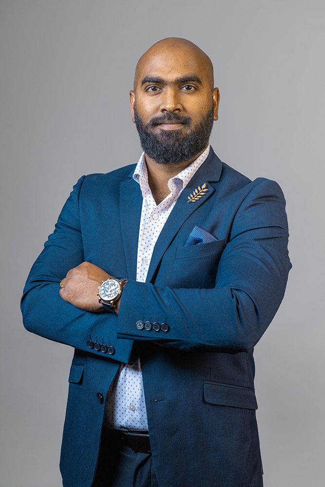 Executive headshot man teal blazer arms crossed confident professional pose