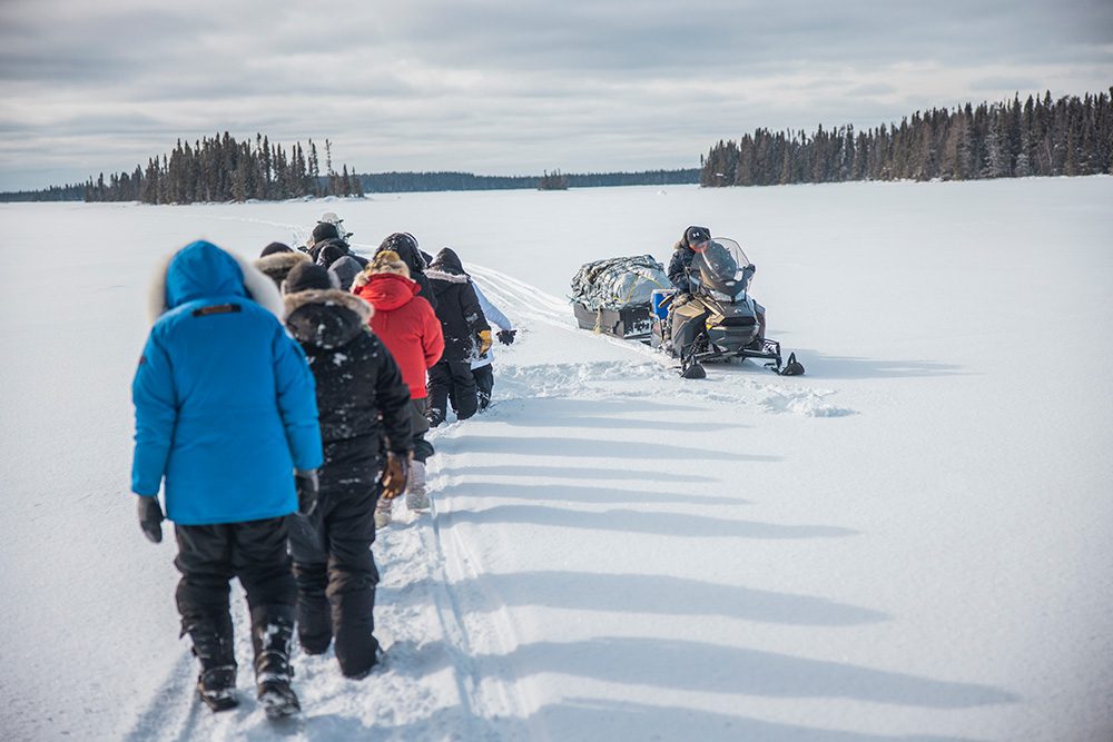 Group checking trapline during educational winter camping trip Northern Ontario