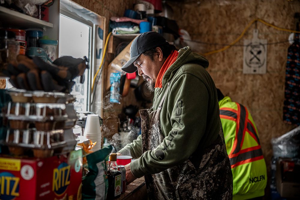 Students learning indoor winter camping skills food preparation remote shelter