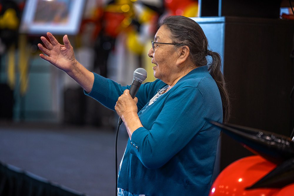 Indigenous elder speaking at graduation ceremony with microphone Thunder Bay