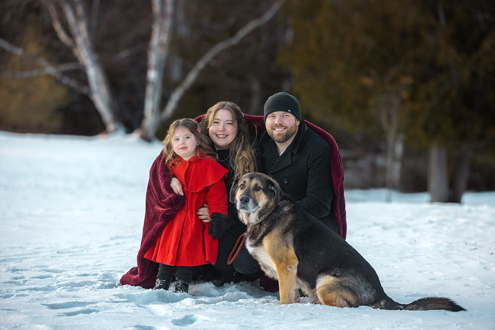 Family including beloved dog in winter family photography session with blanket