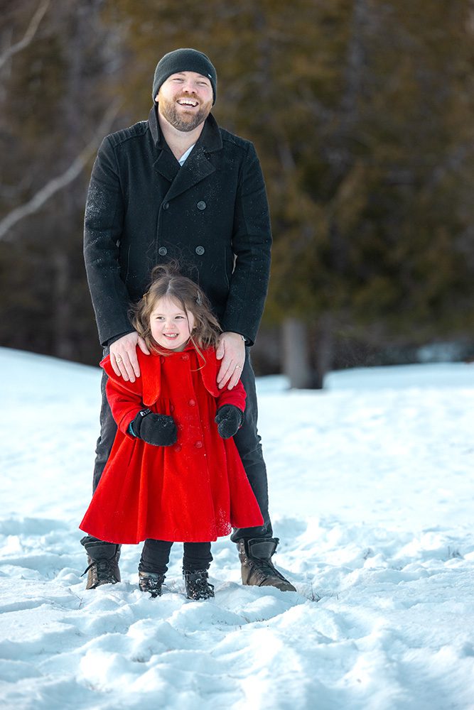 Proud father and daughter smiling together during winter family photography session