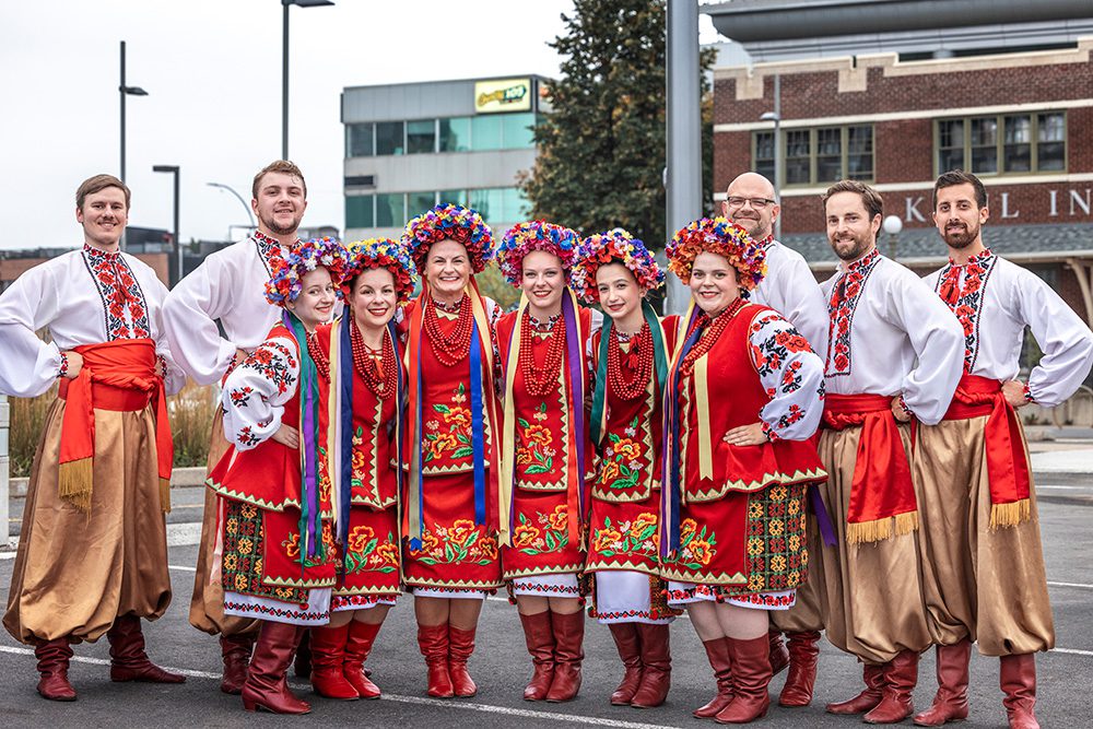 Ukrainian dance troupe in traditional red embroidered costumes posing together