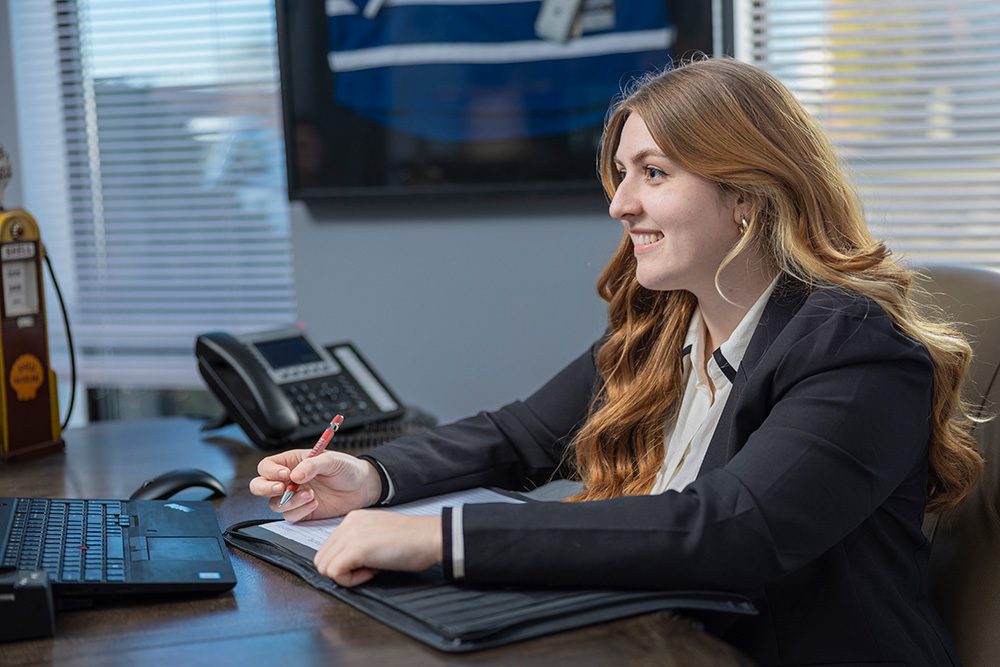 Female office professional working at desk with laptop and notepad at Titan Transline