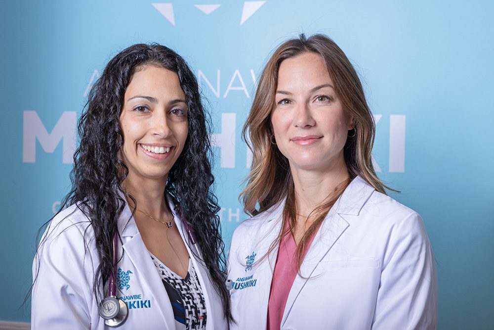 Two female physicians in white lab coats smiling at Anishnawbe Mushkiki medical center