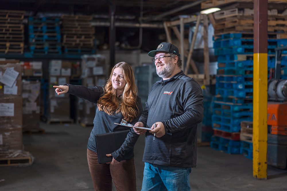 Warehouse manager and office staff collaborating in logistics facility