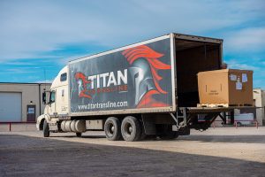 Titan Transline branded semi-truck trailer showing company logo and contact information