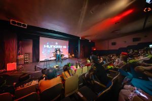 Wide angle shot of belly dancer performing on stage for seated audience