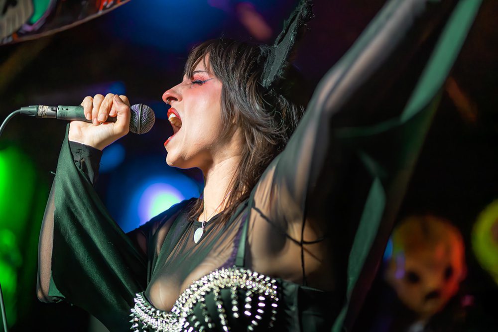 Close-up of female singer with red lips performing intensely with microphone