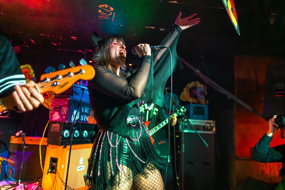 Female rock singer performing passionately with microphone and raised arm