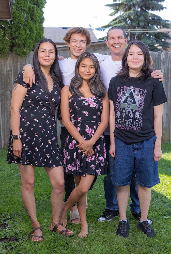 Family of five standing together in backyard including parents and three teenage children for the Backyard Photoshoot Thunder Bay